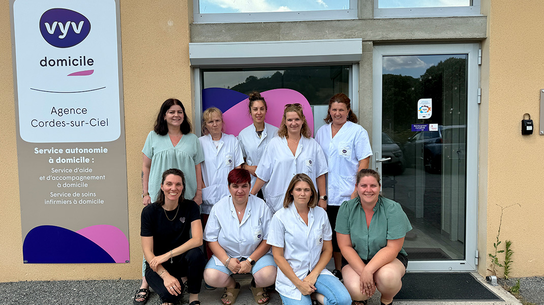 L'équipe des aides à domicile pose devant une agence à l'enseigne VYV Domicile